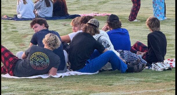 senior sunrise-guys sitting on the football field