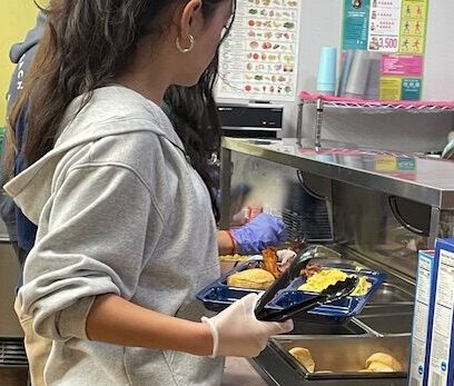 The students serve the hot breakfast.